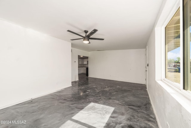unfurnished room featuring ceiling fan and concrete floors