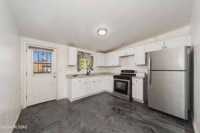kitchen featuring white cabinets, vaulted ceiling, sink, and stainless steel appliances