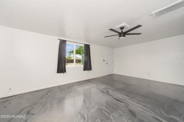 unfurnished room featuring ceiling fan, concrete floors, and a textured ceiling