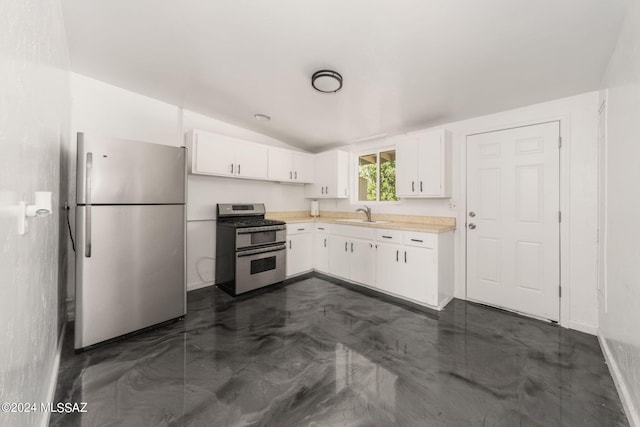 kitchen with white cabinetry, appliances with stainless steel finishes, sink, and lofted ceiling