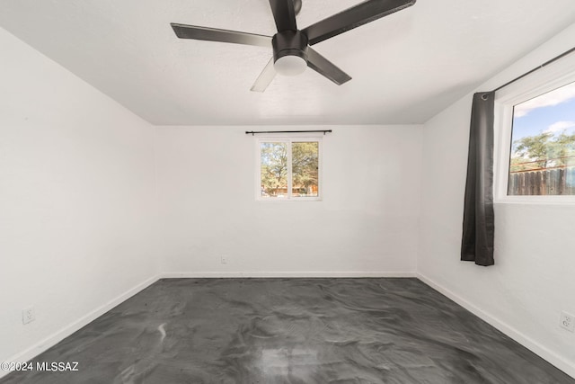 empty room featuring ceiling fan and concrete flooring