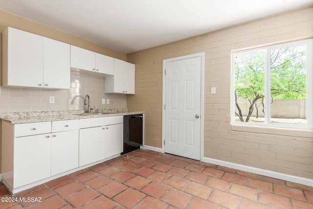 kitchen with light tile patterned flooring, backsplash, sink, and white cabinets