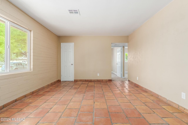 tiled spare room featuring plenty of natural light