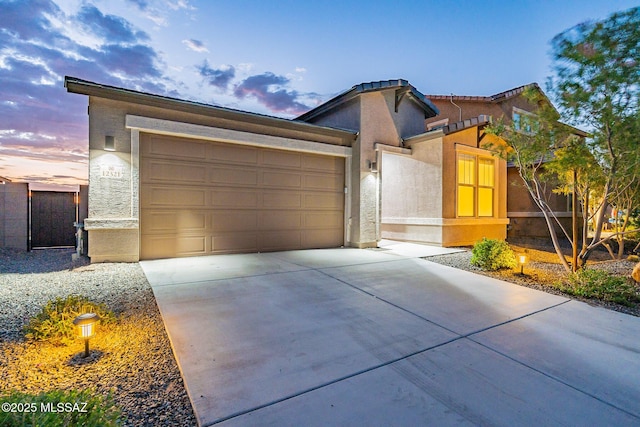 view of front of home with driveway, a garage, and stucco siding