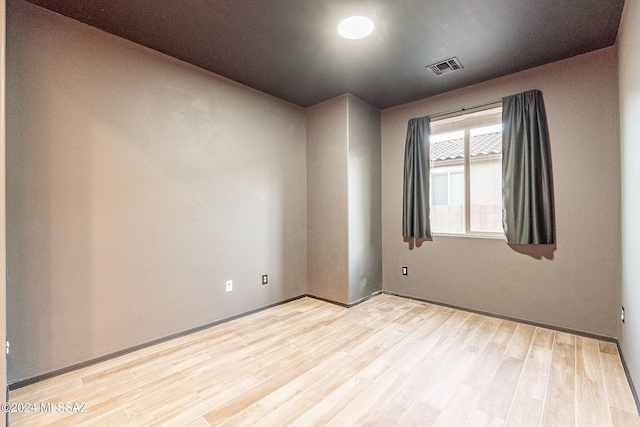 spare room featuring visible vents and light wood finished floors