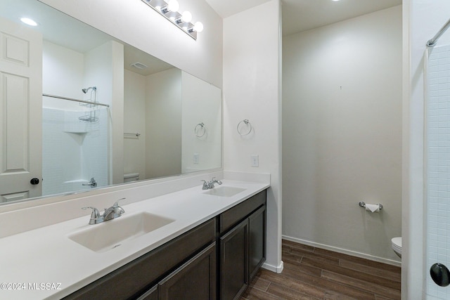 bathroom featuring walk in shower, a sink, and toilet