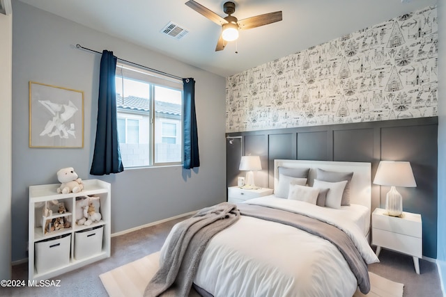 carpeted bedroom with baseboards, visible vents, a ceiling fan, and wainscoting