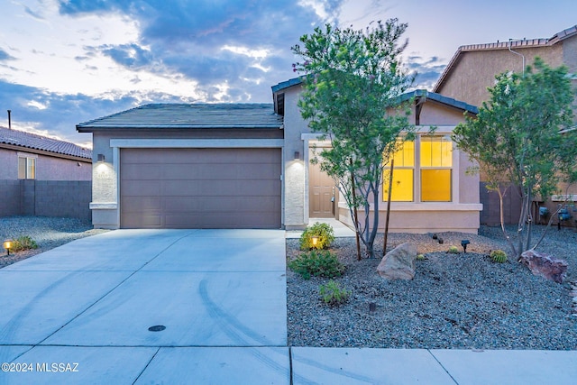 view of front of house featuring a garage, concrete driveway, and stucco siding