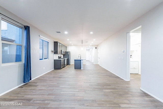 kitchen with light countertops, light wood-type flooring, a sink, and visible vents