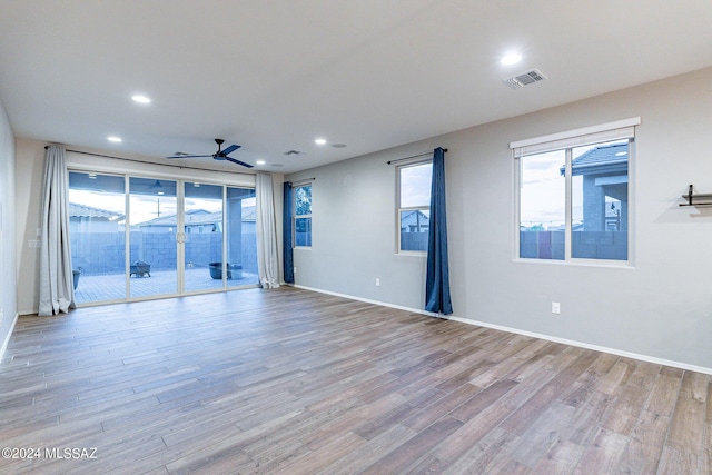 empty room with a ceiling fan, recessed lighting, visible vents, and wood finished floors