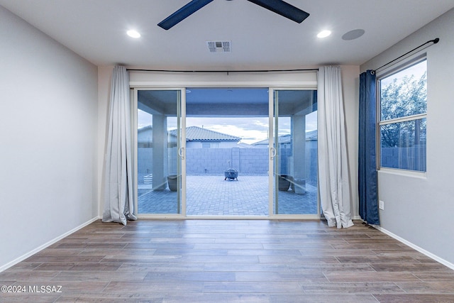 unfurnished room featuring baseboards, ceiling fan, visible vents, and wood finished floors