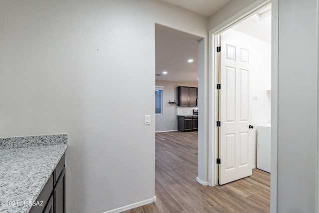 hallway featuring recessed lighting, light wood-type flooring, washer / dryer, and baseboards