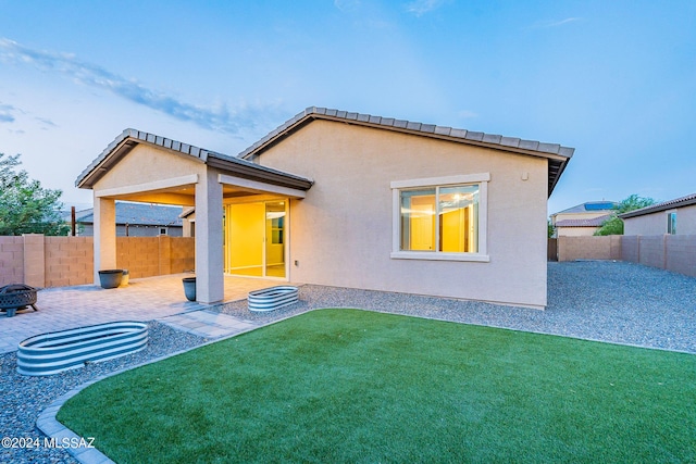 back of property featuring a patio area, a fenced backyard, a yard, and stucco siding