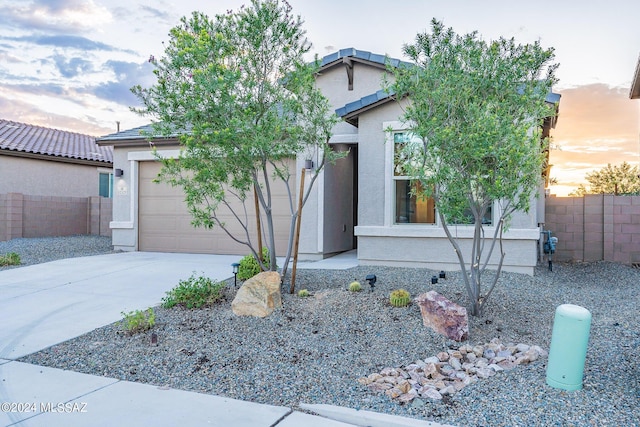 view of front of property featuring a garage, driveway, and stucco siding