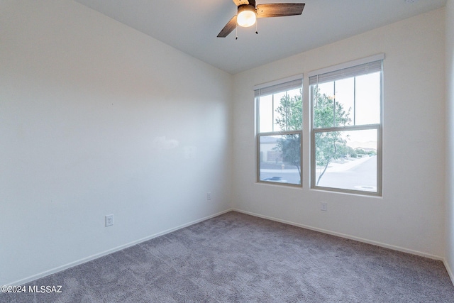 spare room featuring a ceiling fan, carpet flooring, vaulted ceiling, and baseboards