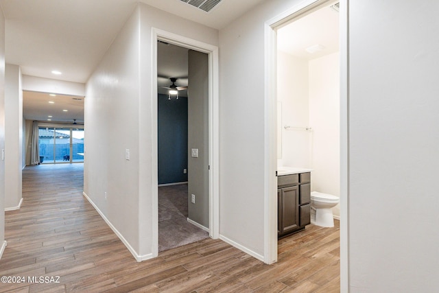 corridor with recessed lighting, light wood-type flooring, and baseboards