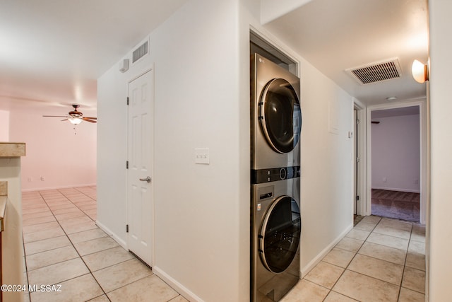 laundry room featuring ceiling fan, stacked washer / dryer, and light tile patterned floors