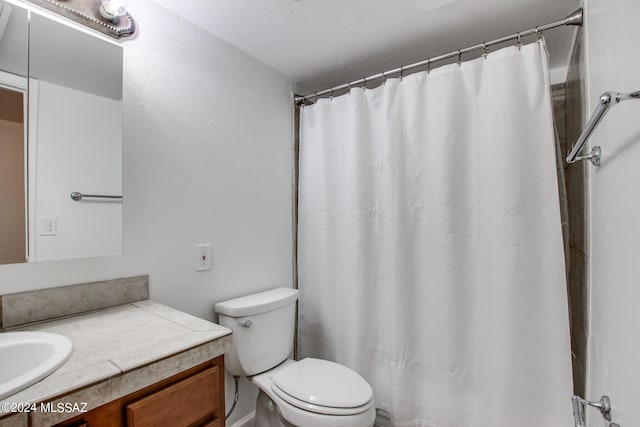 bathroom with vanity, curtained shower, and toilet