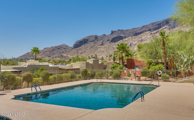 view of swimming pool with a patio area and a mountain view