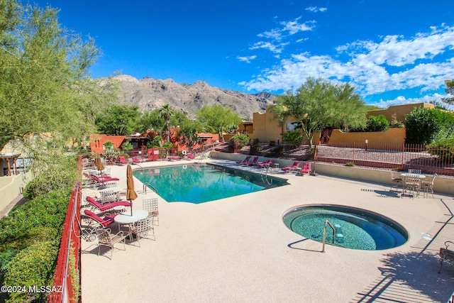 view of pool featuring a patio, a mountain view, and a community hot tub