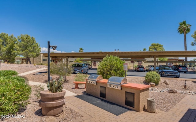 view of patio with area for grilling, a grill, and a carport