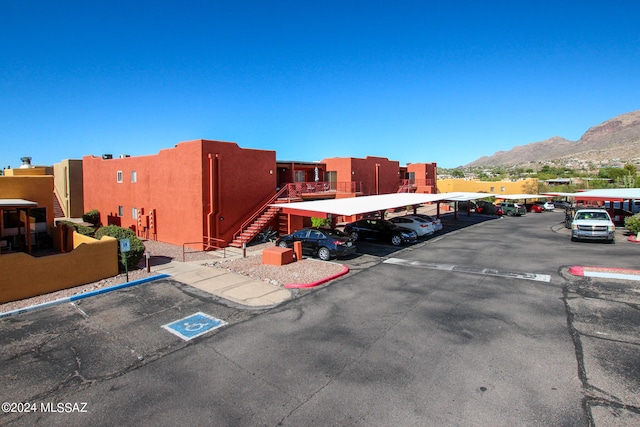 view of parking / parking lot with a mountain view and a carport