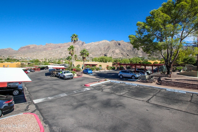 view of parking / parking lot with a mountain view and a carport