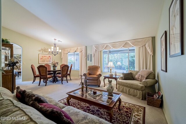 living room featuring vaulted ceiling, a notable chandelier, and light carpet