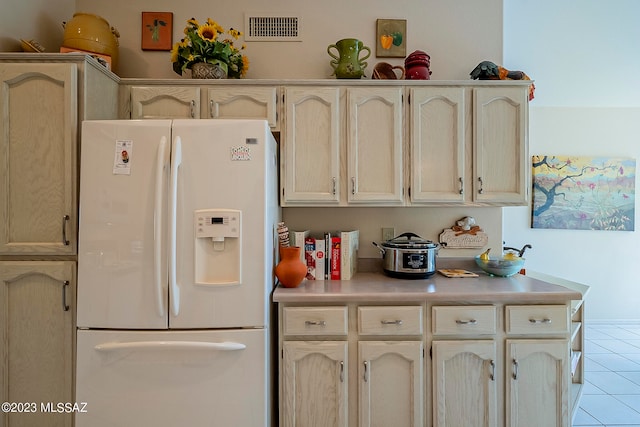 kitchen featuring white fridge with ice dispenser and light tile patterned flooring