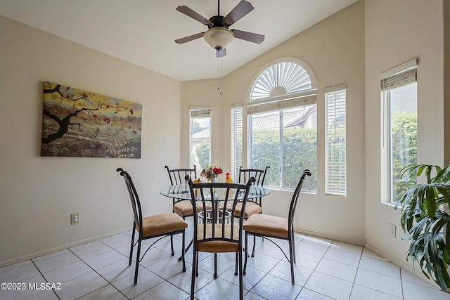 dining area featuring light tile patterned floors, ceiling fan, vaulted ceiling, and baseboards