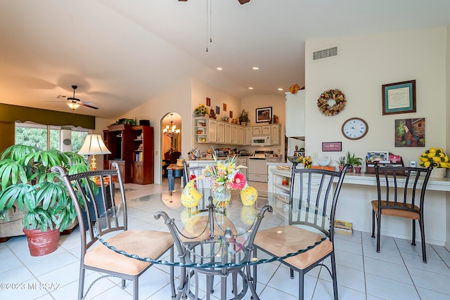 tiled dining space with ceiling fan and vaulted ceiling