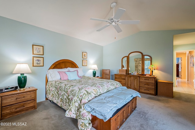 bedroom with lofted ceiling, ceiling fan, and dark colored carpet