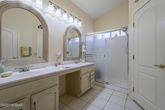 bathroom with tile patterned flooring, vaulted ceiling, a shower with door, and vanity