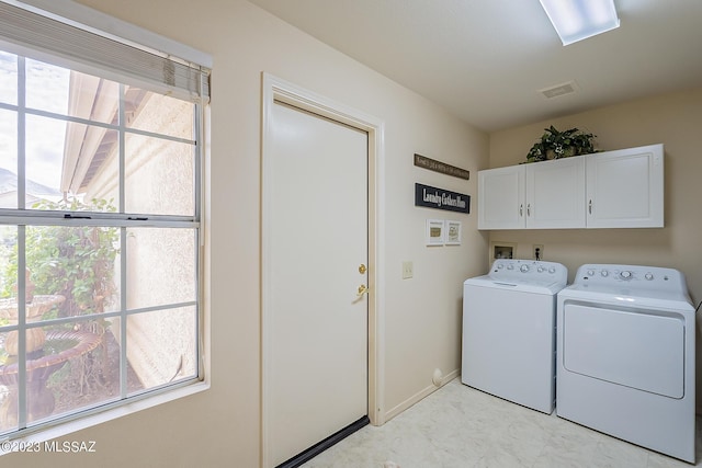 clothes washing area featuring visible vents, baseboards, washer and dryer, marble finish floor, and cabinet space