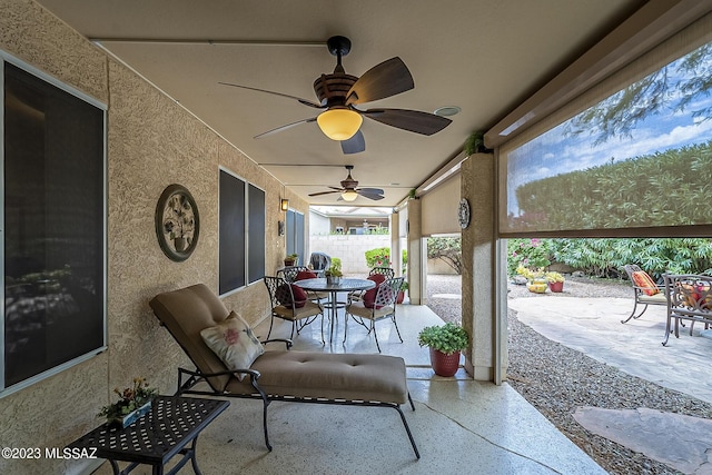 view of patio featuring ceiling fan, outdoor dining space, and fence