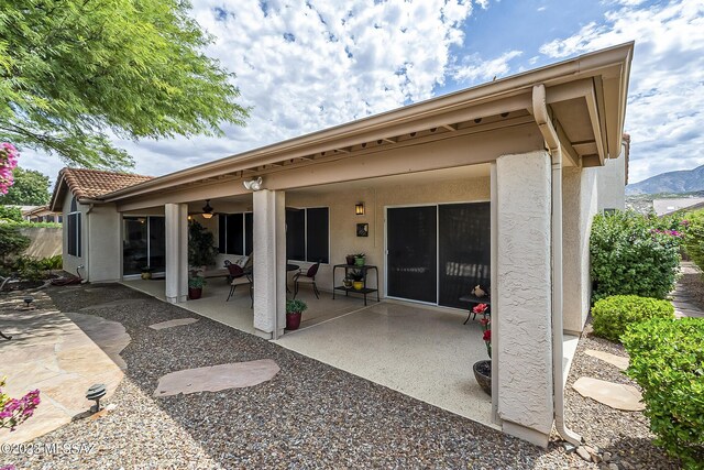 rear view of property featuring a patio and a mountain view