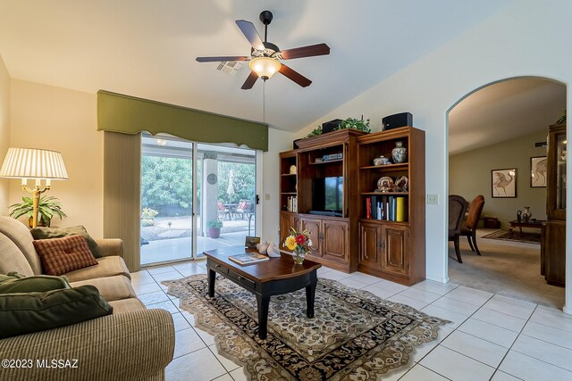 tiled living room with ceiling fan and vaulted ceiling