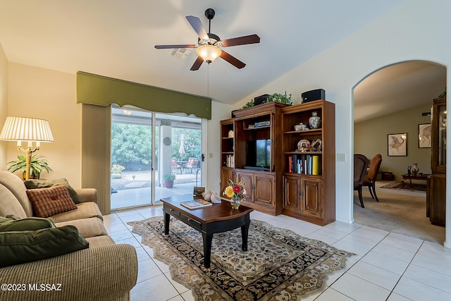 living room with lofted ceiling, light tile patterned floors, and arched walkways