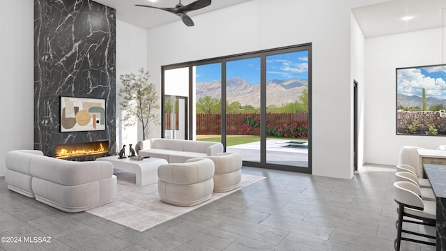 living room featuring a fireplace, a high ceiling, and a mountain view