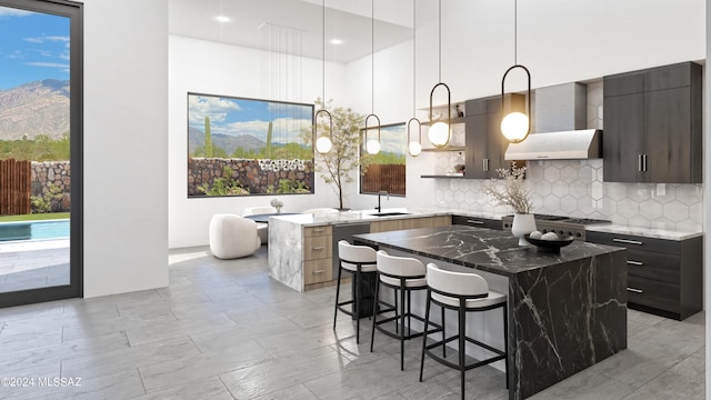 kitchen featuring a mountain view, dark stone counters, a kitchen breakfast bar, sink, and a center island