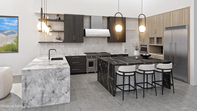 kitchen featuring tasteful backsplash, a breakfast bar area, decorative light fixtures, sink, and high end appliances