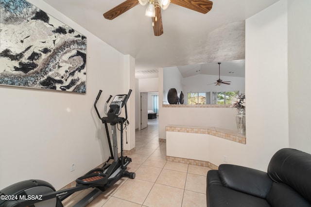 exercise room with light tile patterned floors, vaulted ceiling, and ceiling fan