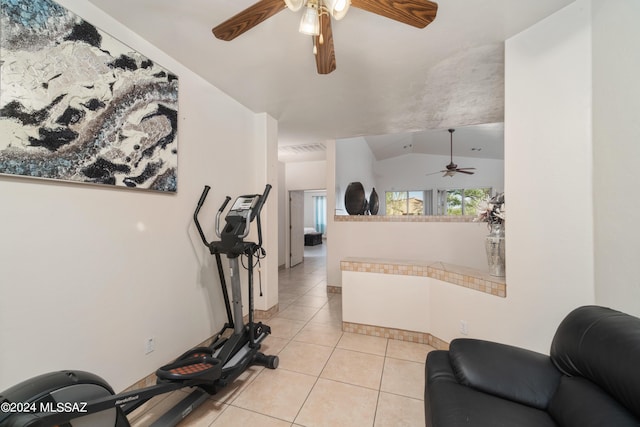 exercise room featuring light tile patterned floors, visible vents, lofted ceiling, and a ceiling fan