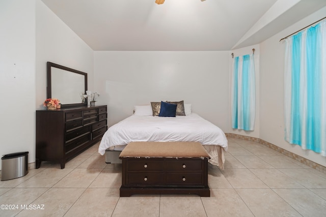 bedroom featuring lofted ceiling, light tile patterned floors, and baseboards