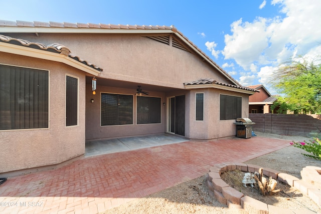 back of house with a ceiling fan, a patio, a tiled roof, fence, and stucco siding