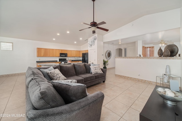 living area featuring lofted ceiling, ceiling fan, light tile patterned flooring, and baseboards