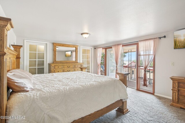 carpeted bedroom featuring baseboards and access to exterior