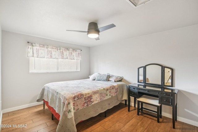 bedroom featuring hardwood / wood-style floors, a ceiling fan, and baseboards