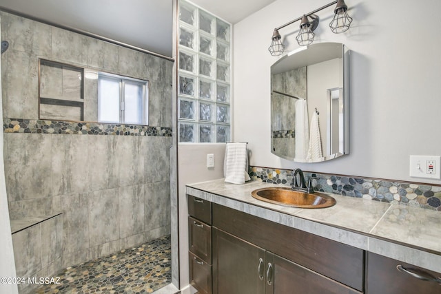 bathroom with tiled shower and vanity