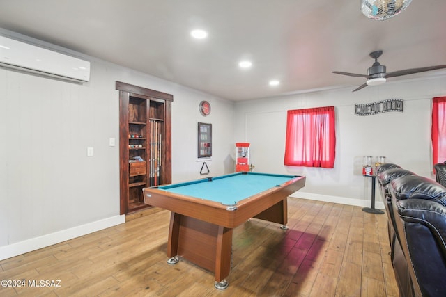 playroom with an AC wall unit, baseboards, hardwood / wood-style flooring, a ceiling fan, and billiards
